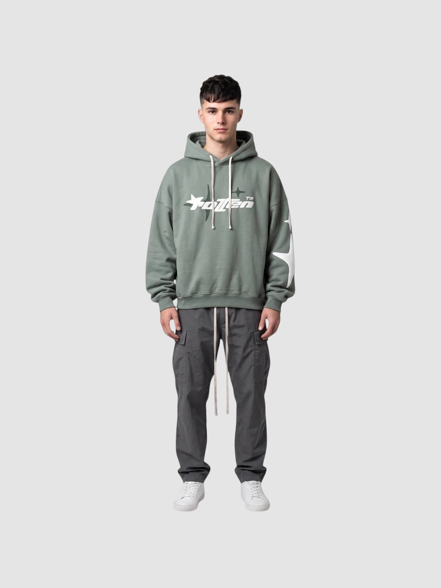 Y2K Avenue sage green oversized hoodie with white star graphic and lettering, worn by a male model with cargo pants.