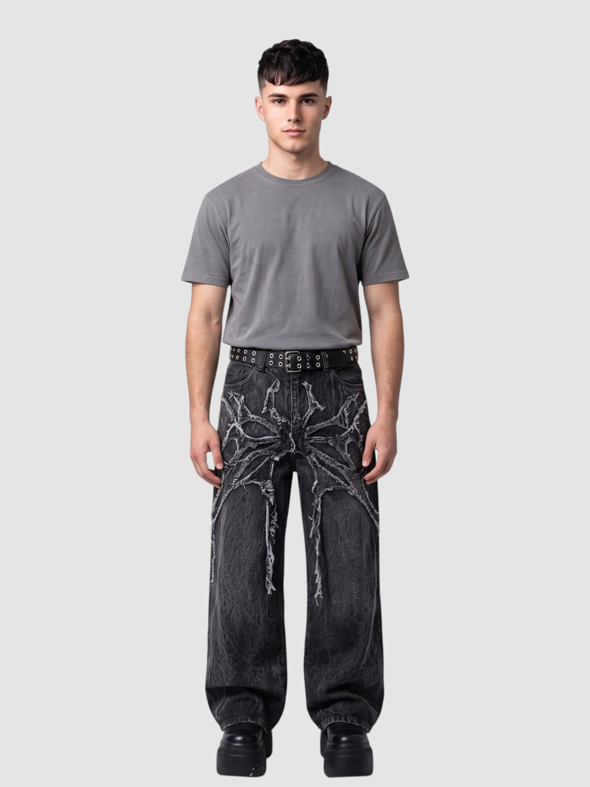 Y2K Avenue wide-leg acid wash black denim jeans with raw-edge spiderweb fabric appliqués radiating from the waist.