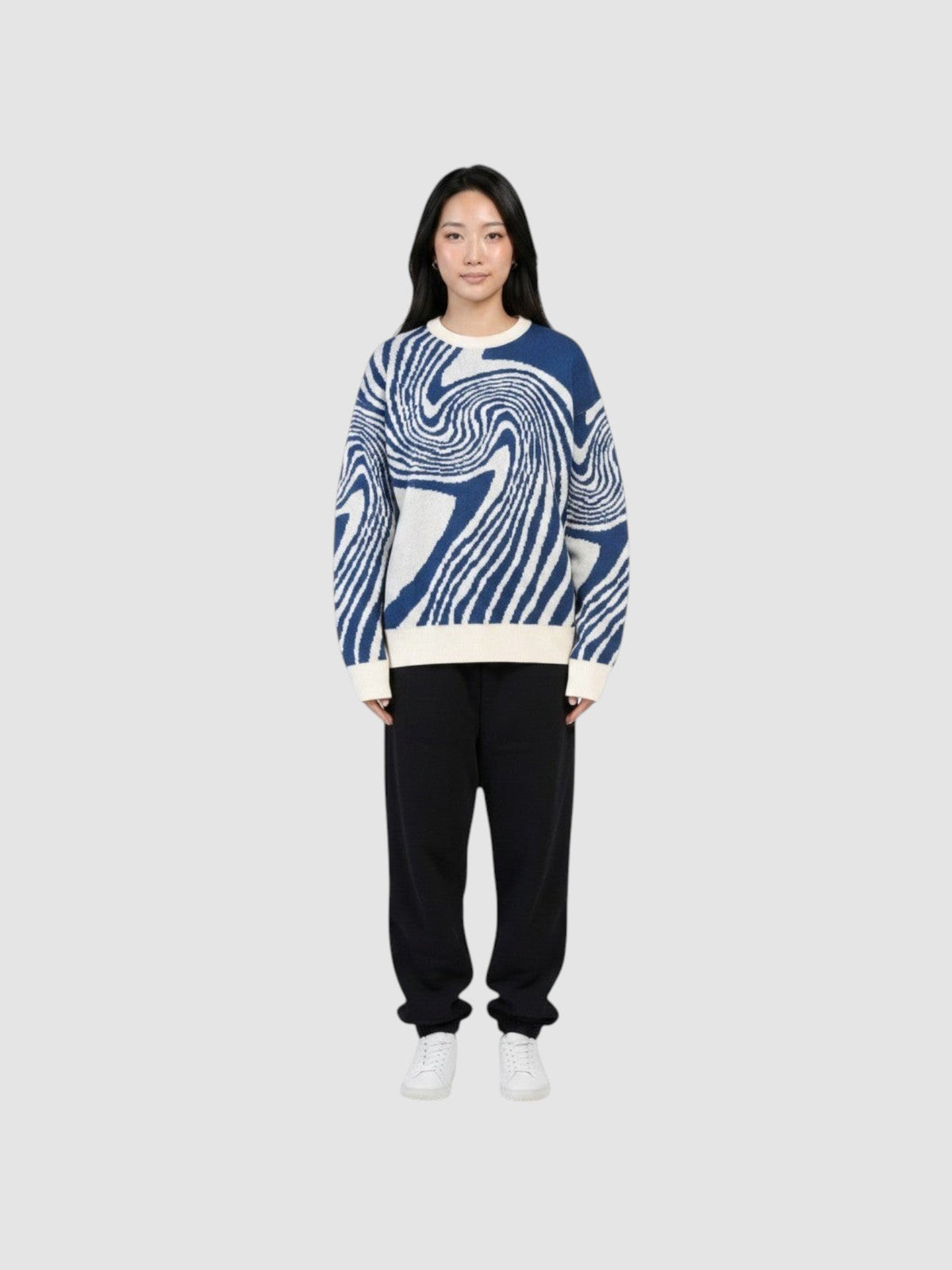 Y2K AVENUE model wearing a lightweight navy and off-white spiral pattern knit sweater with a round neck.