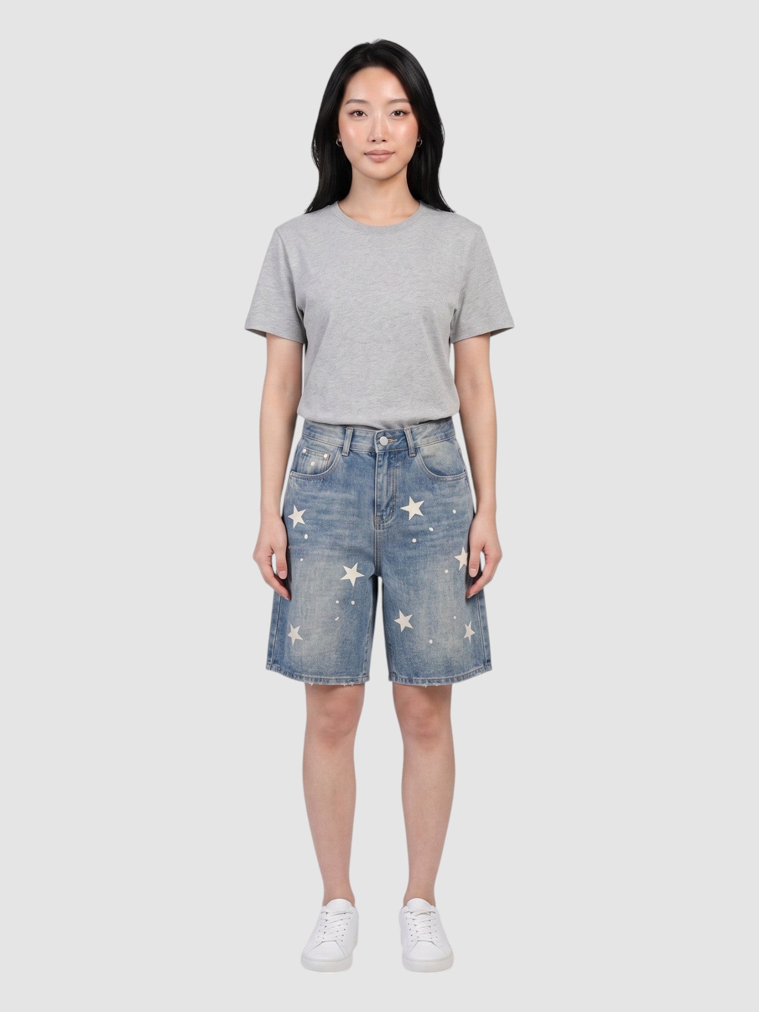 Y2K AVENUE high-waisted light blue denim jorts featuring scattered off-white star prints, worn by a model.