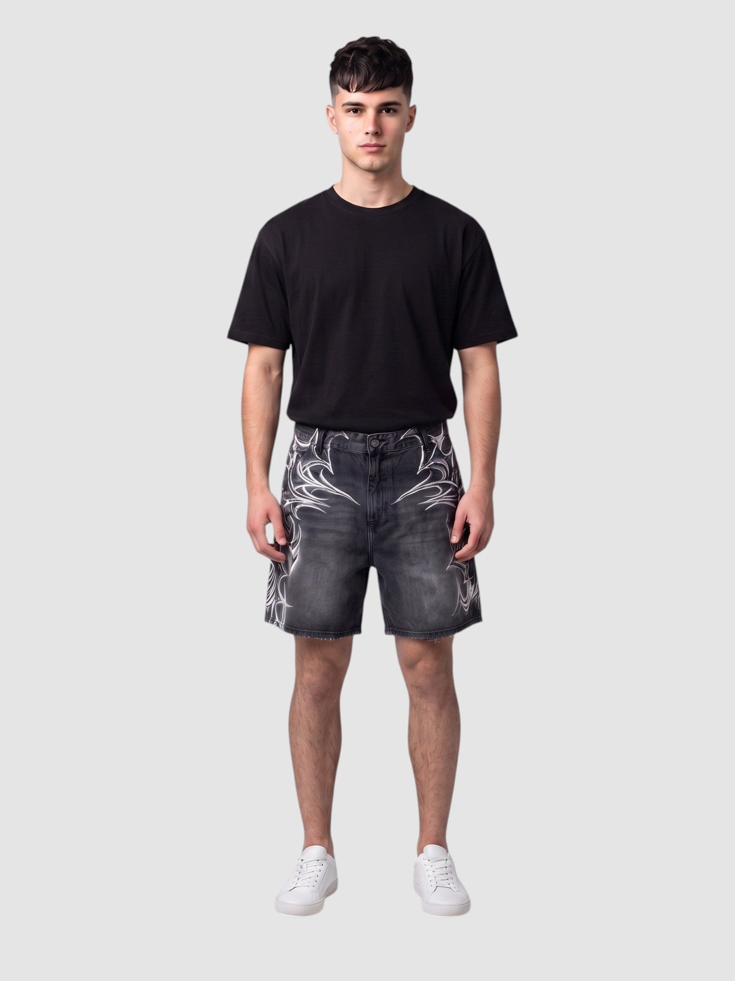 Y2K Avenue black denim jorts featuring white airbrushed tribal motifs, raw hem, and loose fit on a male model.