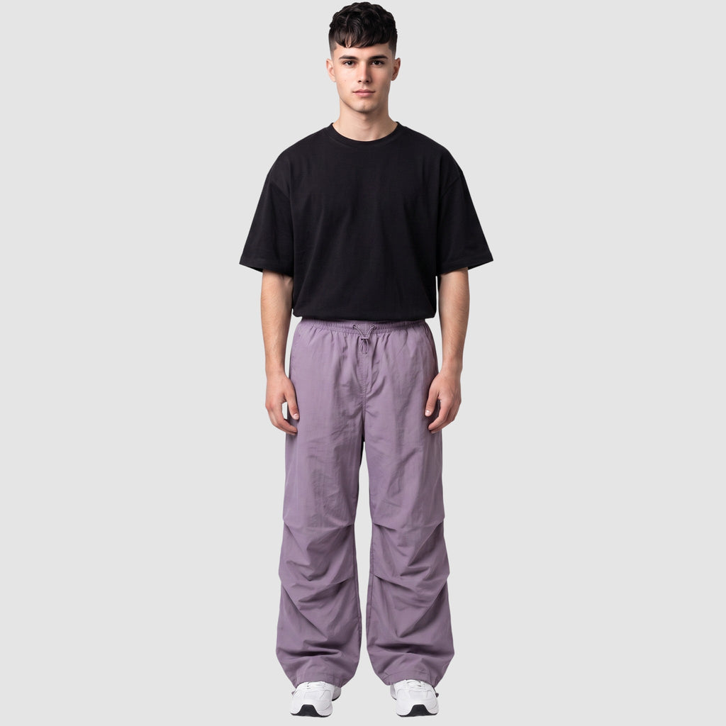 Y2K AVENUE model wearing a high-waisted matte violet parachute pant with gathered knees and adjustable drawstrings.