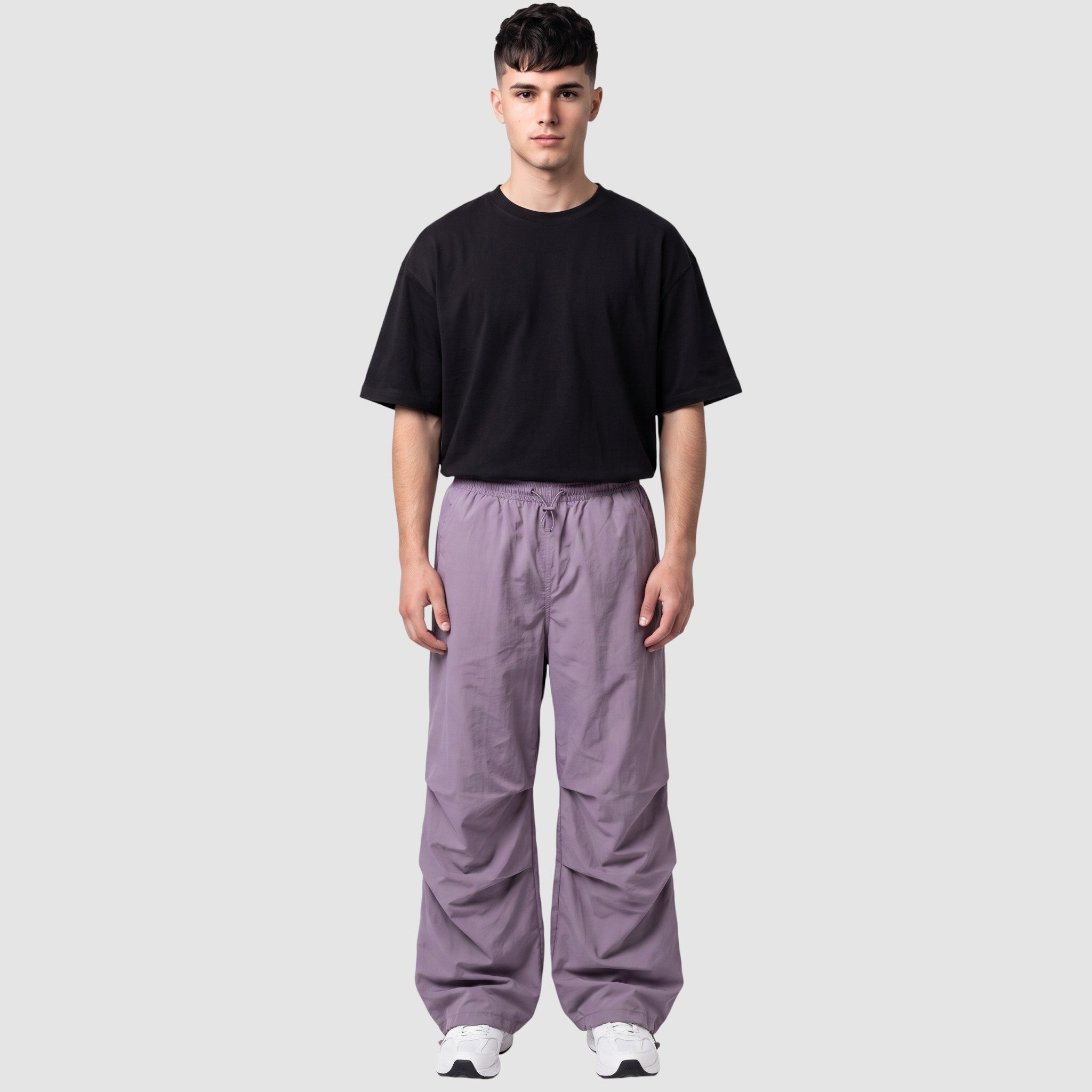 Y2K AVENUE model wearing a high-waisted matte violet parachute pant with gathered knees and adjustable drawstrings.