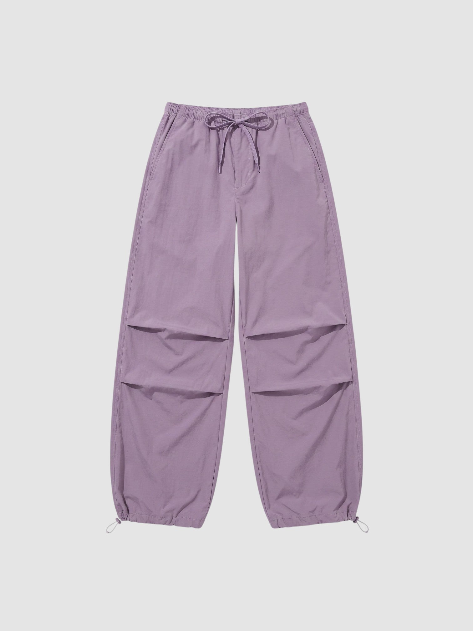 Y2K Avenue high-waisted violet parachute pants in matte nylon with adjustable drawstring waist and ankle cuffs.