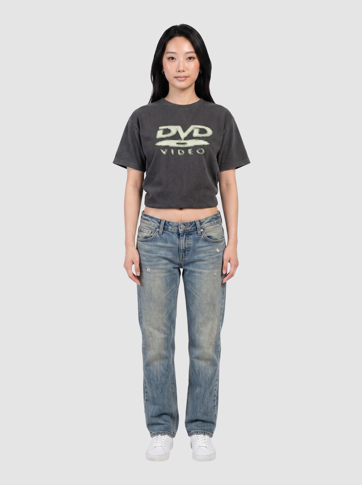 Y2K Avenue black washed DVD Video graphic t-shirt worn by a model with blue jeans and white sneakers