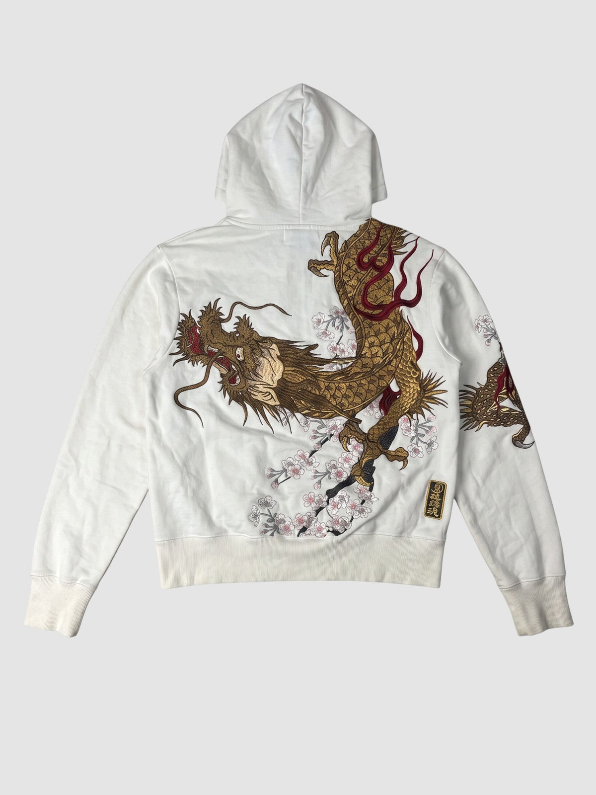 Y2K Avenue white zip-up hoodie featuring a large golden dragon and cherry blossom graphic on the back