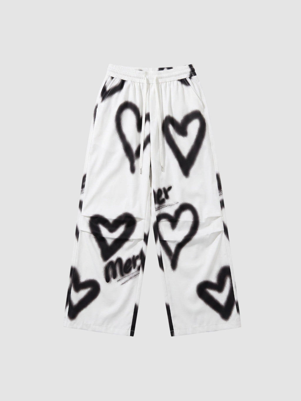 Y2K Avenue white wide-leg pants featuring black spray-painted heart motifs and an elastic drawstring waist.