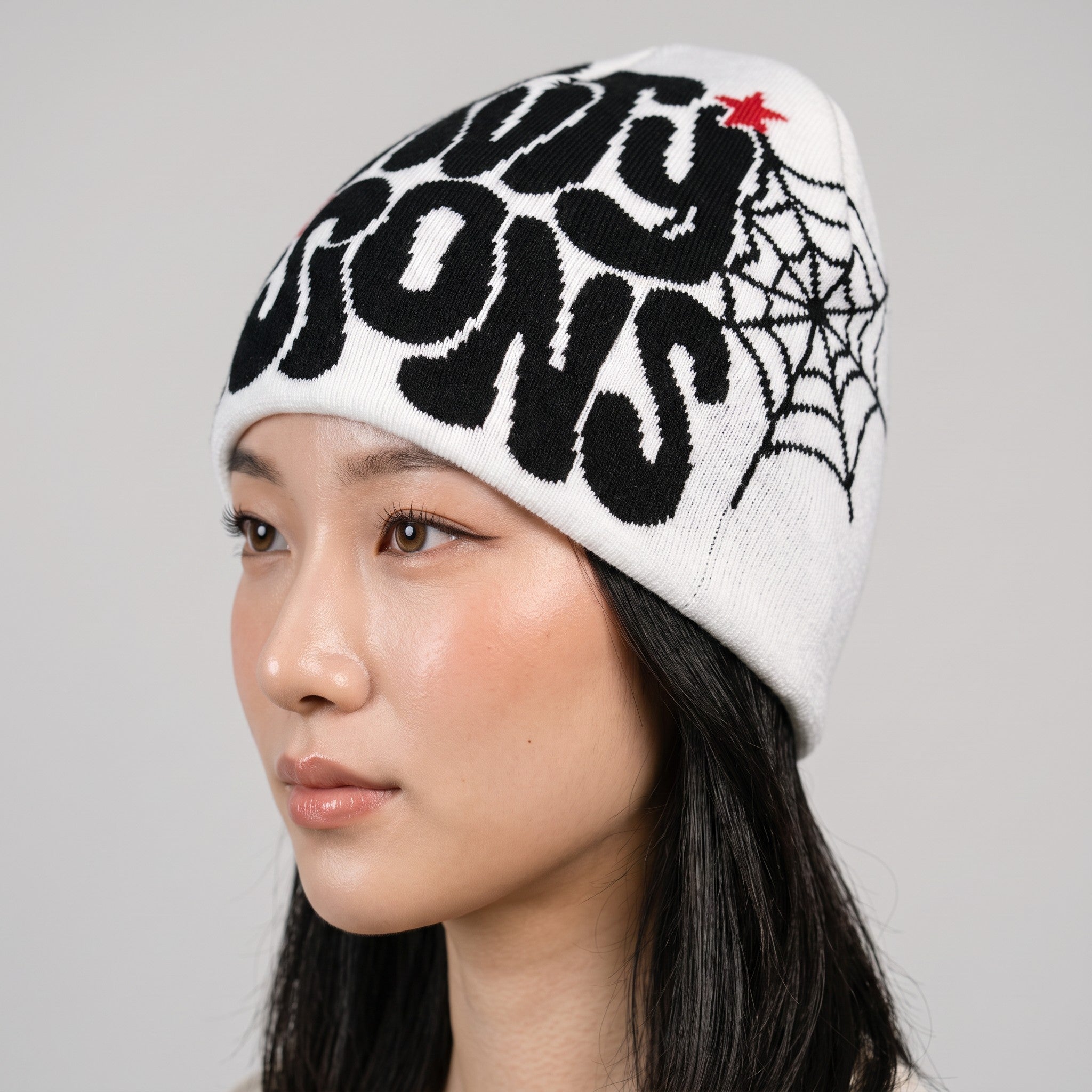 Y2K AVENUE white knit beanie with black graphic print and spiderweb design worn by a model